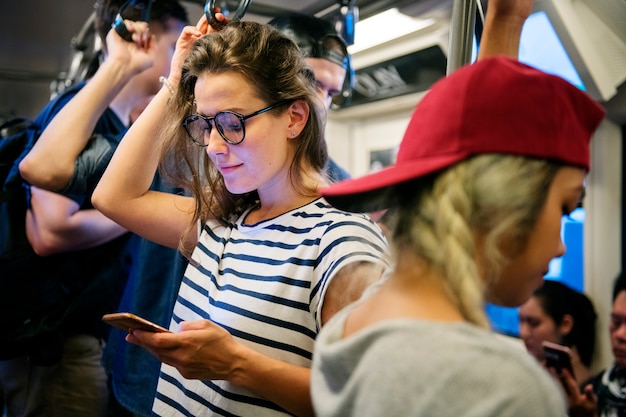 Jonge vrouw met behulp van een smartphone op de metro