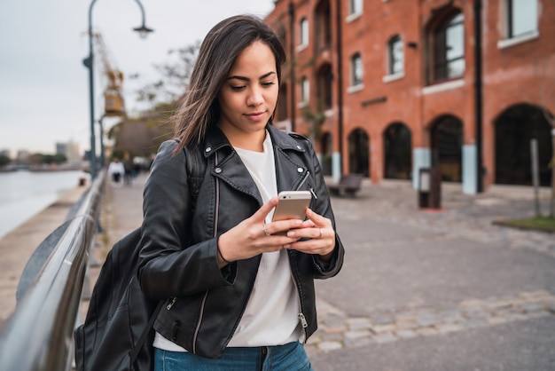 Jonge vrouw met behulp van haar mobiele telefoon.