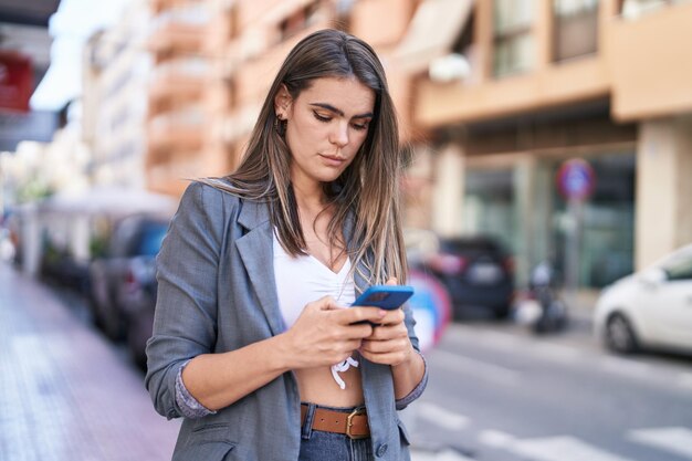 Jonge vrouw met behulp van smartphone op straat