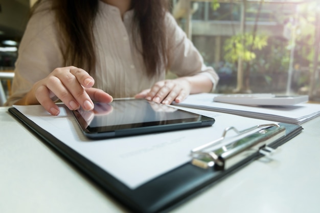 Jonge vrouw met behulp van tablet tijdens het werken