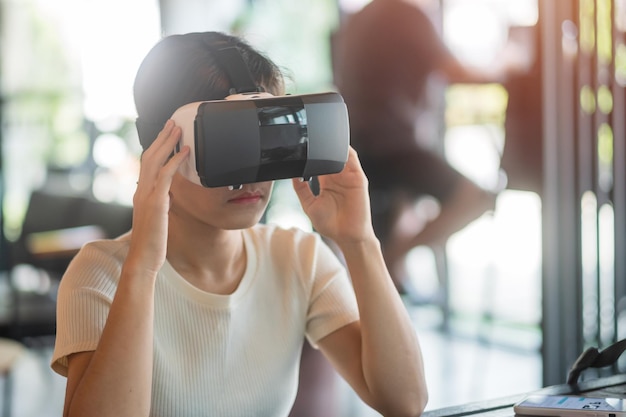 Jonge vrouw met behulp van virtual reality headset VR Toekomstige digitale technologie game entertainment metaverse NFT en 3D cyberspace concept