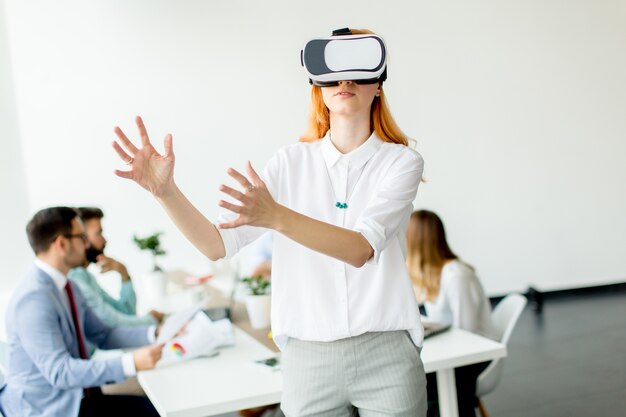 Jonge vrouw met behulp van virtual reality simulator op kantoor