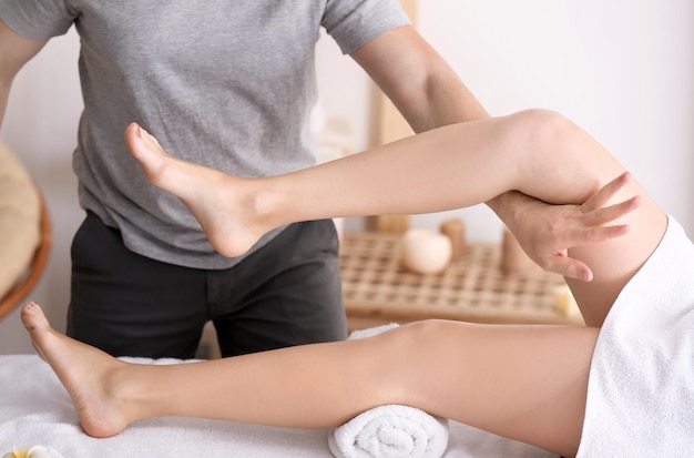 Jonge vrouw met benen massage in spa salon