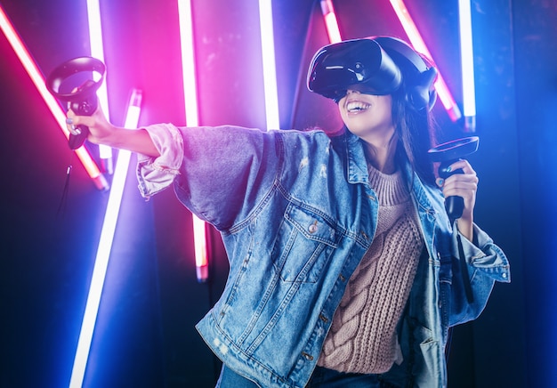 Jonge vrouw met blauwe denim jas met behulp van virtual reality bril
