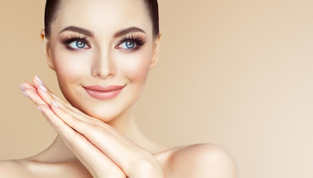 Jonge vrouw met blauwe ogen met zachte make-up op het gezicht tedere glimlach op haar lippen Cosmetologie en schoonheid