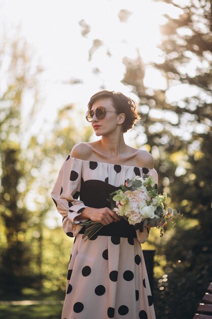 Foto jonge vrouw met bloemboeket in park