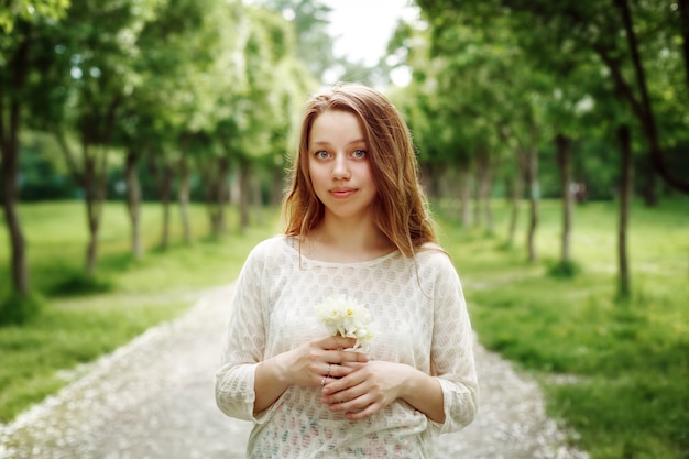 Jonge vrouw met bloemen buitenshuis