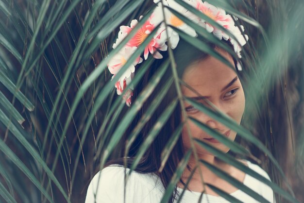 Foto jonge vrouw met bloemen die wegkijkt.