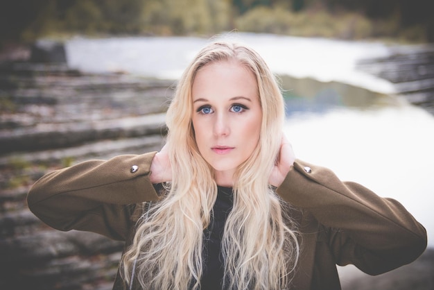 Foto jonge vrouw met blond haar bij de rivier.