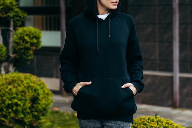 Jonge vrouw met bril en zwarte hoodie