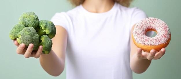 Jonge vrouw met broccoli en donut op kleur achtergrond close-up