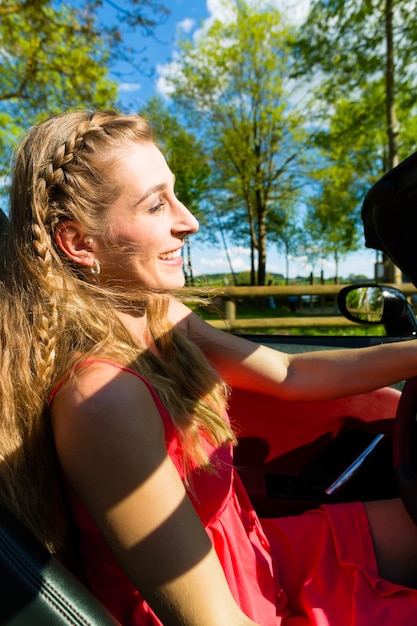 Foto jonge vrouw met cabriolet in de zomer op dagtocht