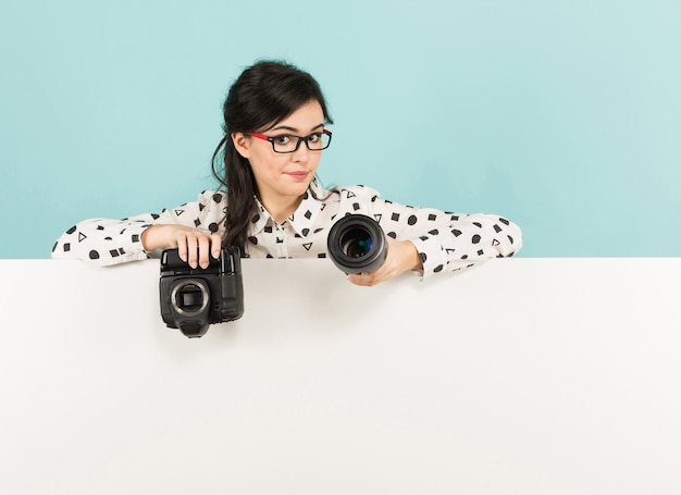 Jonge vrouw met camera en lens