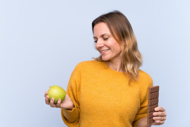 Jonge vrouw met chocolade en een appel