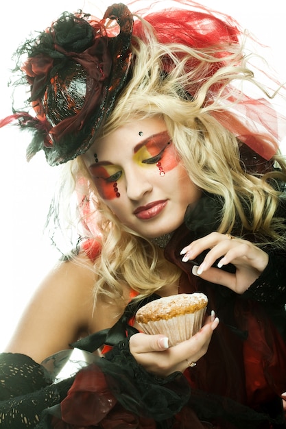 jonge vrouw met creatieve make-up met cake.