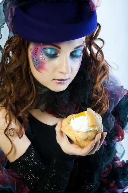 Jonge vrouw met creatieve make-up met cake