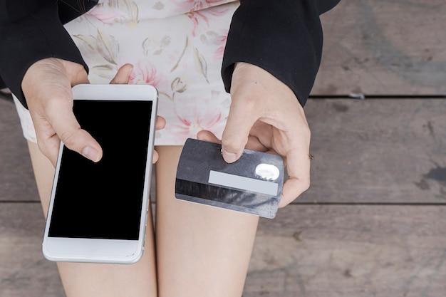 Jonge vrouw met creditcard en het gebruik van mobiele telefoon. Online winkelconcept