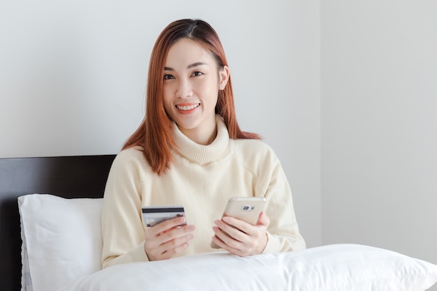 Jonge vrouw met creditcard en het gebruik van mobiele telefoon. Online winkelen concept