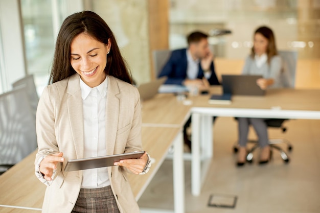 Jonge vrouw met digitale tablet op kantoor