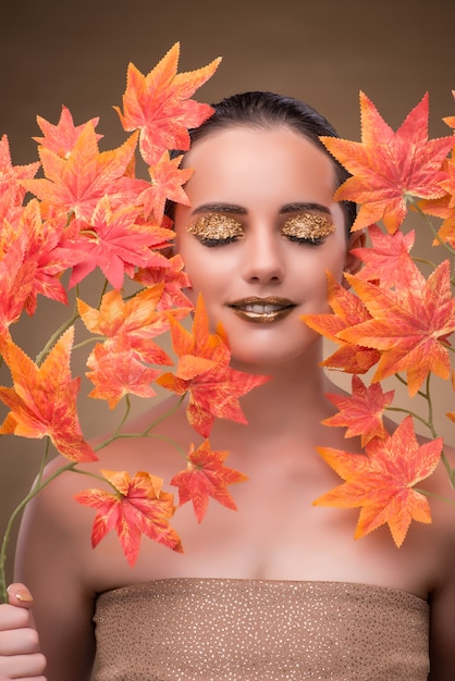 Jonge vrouw met droge herfstbladeren