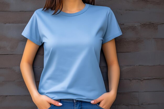 Foto jonge vrouw met een blank blauw t-shirt voor de grijze muur mockup t-shirt sjabloon