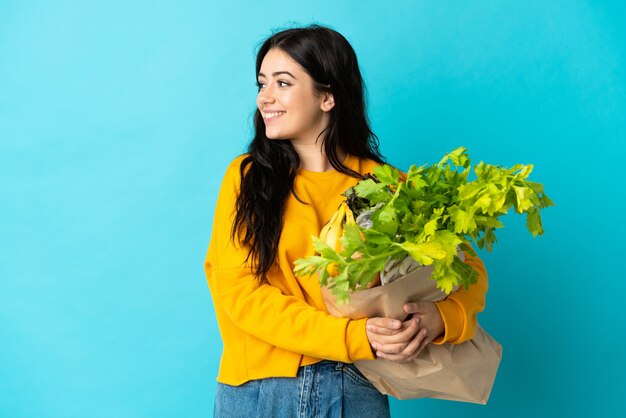 Jonge vrouw met een boodschappentas aan de blauwe kant