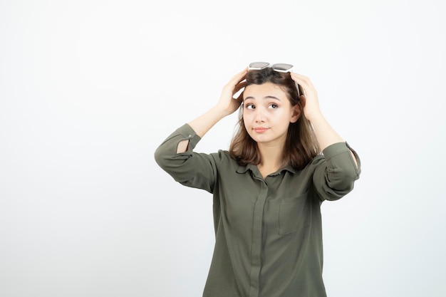 Jonge vrouw met een bril die staat en ergens kijkt. Hoge kwaliteit foto