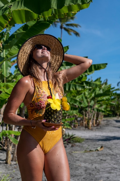 Jonge vrouw met een cocktail in ananas op stranden in het noordoosten van Brazilië