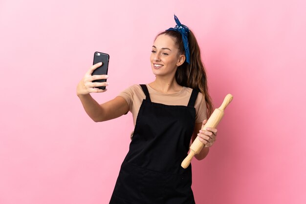 Jonge vrouw met een deegroller die een selfie maakt