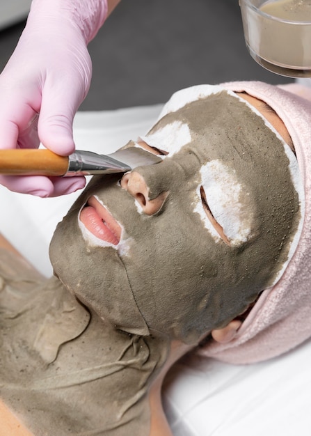 Foto jonge vrouw met een gezichtsbehandeling in de schoonheidssalon