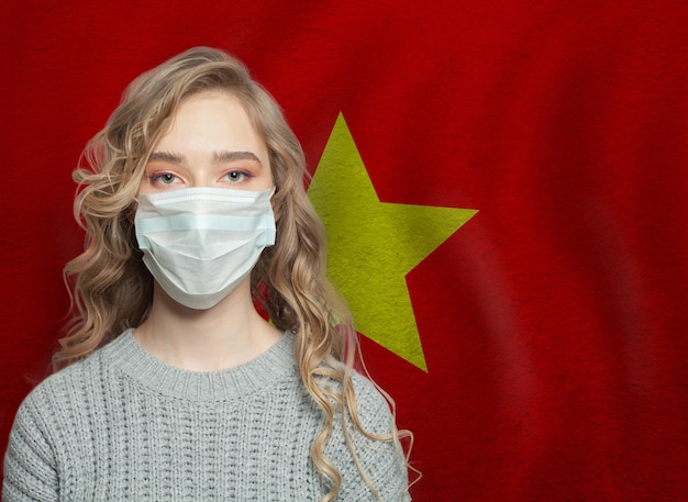 Jonge vrouw met een gezichtsmasker met vlag Gripe-epidemie en virusbeschermingsconcept
