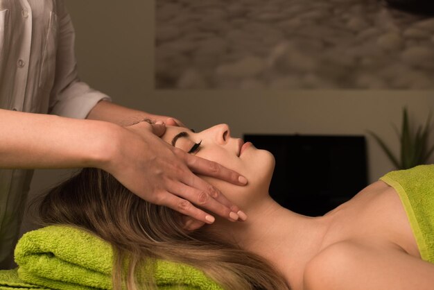 Jonge vrouw met een gezichtsmassage in de spa