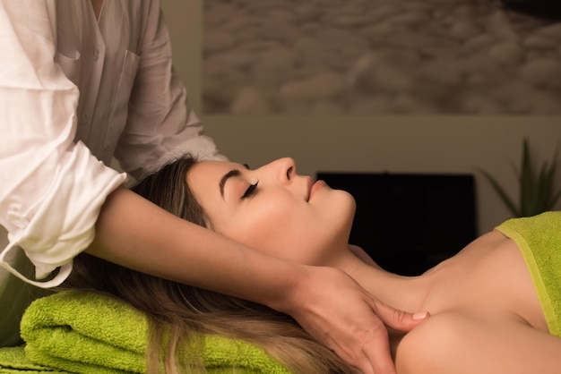 Jonge vrouw met een gezichtsmassage in de spa