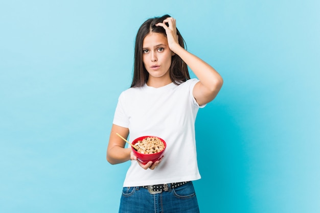 Jonge vrouw met een graankom die geschokt is, heeft ze een belangrijke vergadering onthouden