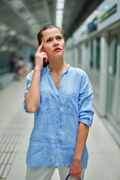 Jonge vrouw met een handtas in metrostation te wachten op de komst van de trein