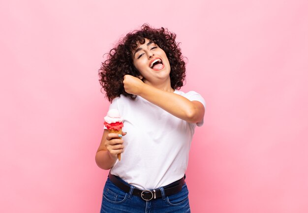 Jonge vrouw met een ijsje voelt zich gelukkig, positief en succesvol, gemotiveerd wanneer ze voor een uitdaging staat of goede resultaten viert