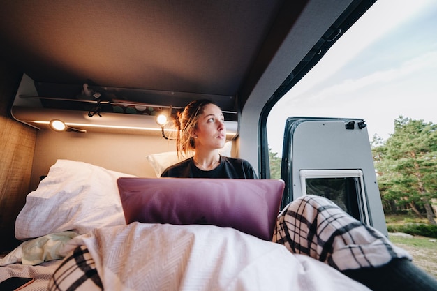Jonge vrouw met een laptop in een camper.