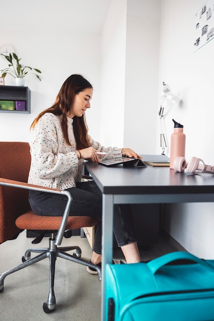 Jonge vrouw met een laptop terwijl ze op tafel zit