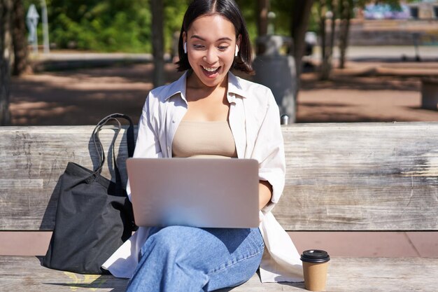 Foto jonge vrouw met een laptop terwijl ze op tafel zit