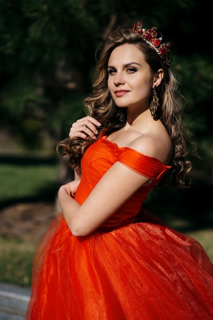 Jonge vrouw met een luxe kroon op haar hoofd en in een rode jurk, close-up