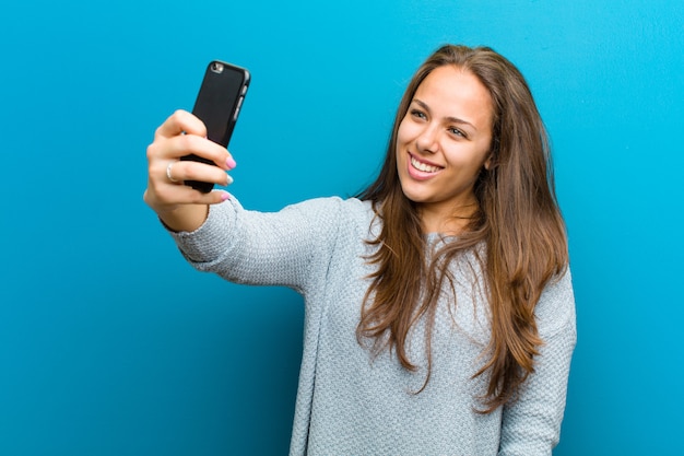 Jonge vrouw met een mobiele telefoon blauw