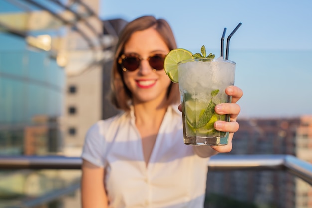 jonge vrouw met een mojito in een dak.