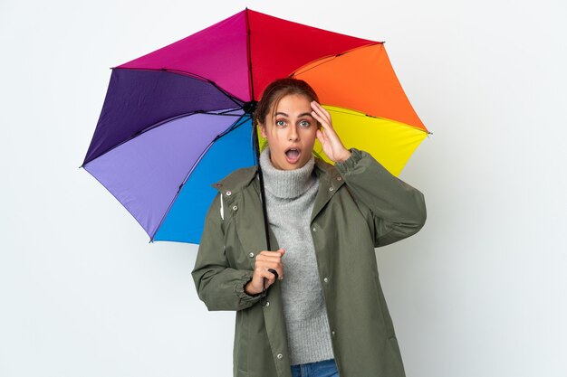 Foto jonge vrouw met een paraplu geïsoleerd met verrassing expressie