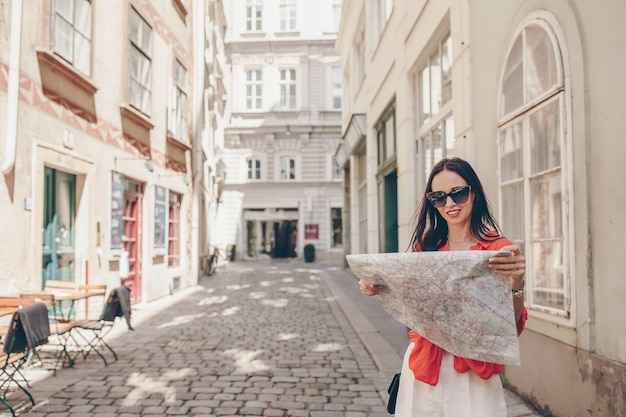 Jonge vrouw met een plattegrond van de stad in de stad. reis toeristenmeisje met kaart in wenen in openlucht tijdens vakantie in europa.