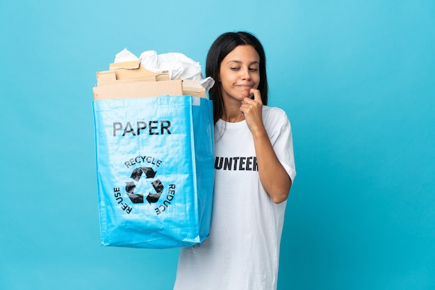 Jonge vrouw met een recycling zak vol papier twijfels en denken