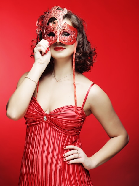 Jonge vrouw met een rode mysterieuze masker
