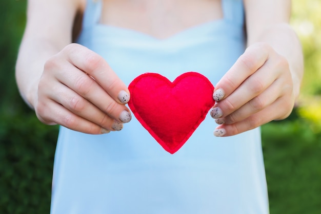 Jonge vrouw met een rood hart in haar handen