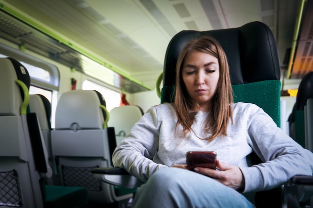 Foto jonge vrouw met een smartphone in een trein