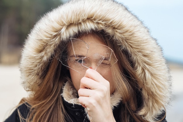 Foto jonge vrouw met een stuk ijs voor haar gezicht.