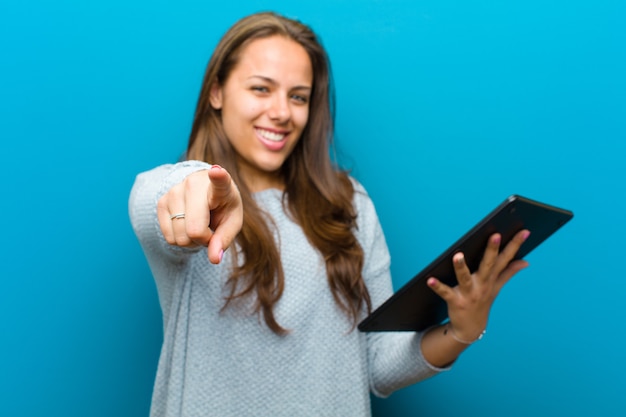 Jonge vrouw met een tablet tegen blauw